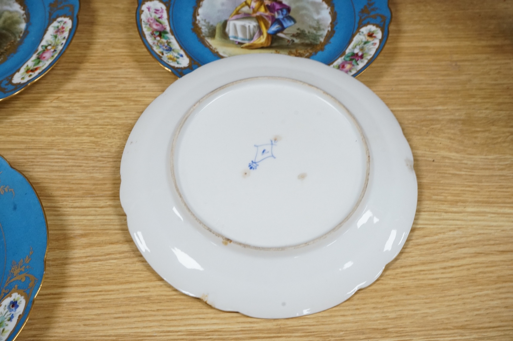 A set of eight 19th century Sevres style bleu celeste ground cabinet plates, each painted with a courting couple, 22cm diameter